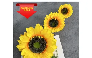 Detailed view of three artificial sunflower heads with bright yellow petals and dark centers