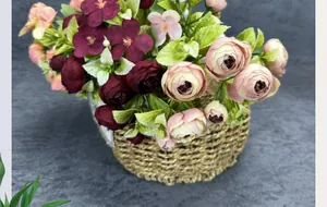 Close-up of mixed artificial roses and peonies in a woven basket for home decor
