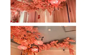 Detailed view of pink artificial cherry blossom trees with traditional red fabric lanterns