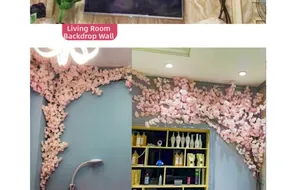 Pink artificial cherry blossom vines decorating a living room background wall and ceiling