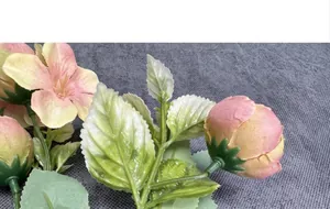 Detail of high-quality silk fabric artificial rose buds with realistic green leaf textures