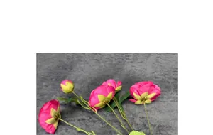 Detailed view of artificial pink silk peonies with green stems on textured fabric