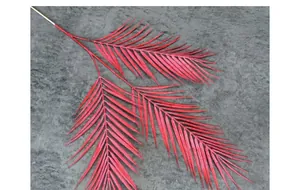 Detail van rode kunstmatige palmblad takken voor bruiloft decor op grijze basis