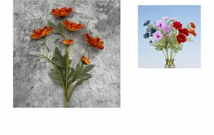 Detail of multi-head orange artificial zinnia petals with realistic green silk leaves
