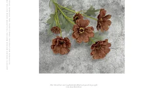 Detailed view of artificial brown Zinnia flowers with realistic green leaves on stone