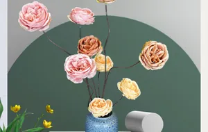 Détail de roses Austin à 3 têtes dans un vase en céramique bleue à texture craquelée