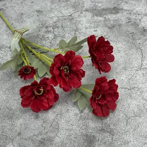 Artificial 6-head zinnia bouquet in deep red with realistic green leaves on grey background