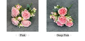 Close-up of pink and dark pink artificial peony bouquets with green leaves on grey cloth