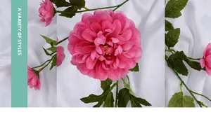 Nahaufnahme von rosa künstlichen Dahlienblüten mit grünem Stiel auf weißem Seidenstoff