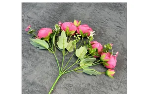 Gros plan d'un bouquet de pivoines roses artificielles avec pétales et feuilles vertes