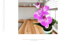 Paarse kunstmatige orchidee in witte keramieken pot op een houten keukenaanrecht