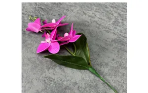 Detail van kunstmatige phalaenopsis orchidee met magenta bloembladen en bladeren