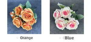 Close-up of artificial rose bouquet in orange and pink tones with green fern leaves
