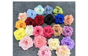 Detailed top view of various colored artificial silk rose heads arranged on gray fabric