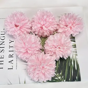 Six light pink artificial hydrangea heads on fashion magazine with palm leaf decor