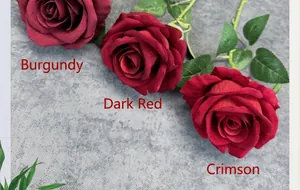 Detailed close-up of velvet artificial roses in wine red, dark red and bright red tones