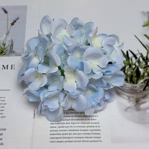 Testa di ortensia artificiale azzurra su una rivista per decorazioni domestiche