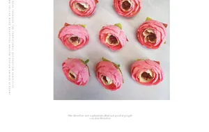 Detail of eight pink handmade fabric rose heads with multi-layer petals and dark stamens