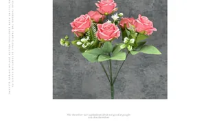 Detail of pink silk roses with white blossoms and green leaves against a gray wall