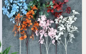 Detalle de hojas de ruscus artificiales en azul y naranja para decoración hogar