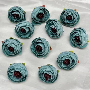 Flat lay of 10 blue-grey silk camellia flower heads for DIY headwear and crafts