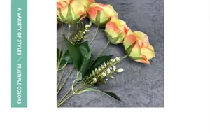 Detailed view of artificial roses bouquet with orange-yellow gradient petals and green leaves