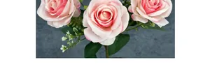 Macro shot of pink artificial roses featuring delicate gradients and green leaves