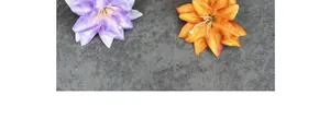 Detailopname van kunstmatige leliebloemen in paars en oranje met zijden textuur