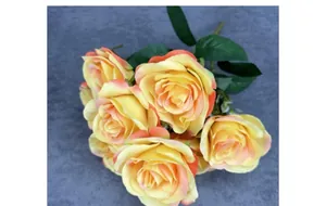 Close-up of artificial yellow orange roses bouquet with silk leaves for home decor