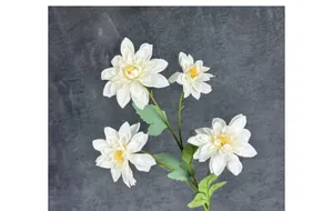 Dettaglio di quattro fiori di dalia in seta bianca con pistilli gialli e foglie verdi