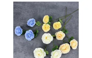 Flat lay of multi-head artificial Ranunculus flowers in assorted pastel colors on grey fabric
