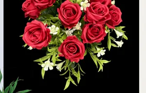 Detail of realistic red faux roses with small white flowers against black background
