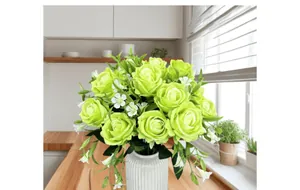 Detail of 15-head light green silk roses in a white ceramic vase on a wooden counter