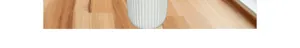 Detail of white vertical fluted ceramic vase base on a natural wood texture tabletop