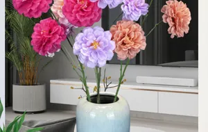 Detalle de flores de hibisco de seda vibrantes en un jarrón de cerámica azul