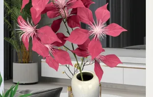Detail of vivid magenta poinsettia faux flowers in a ceramic vase with gold metal stand