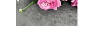 Macro detail of velvet artificial rose petals with pink gradient and realistic leaf texture
