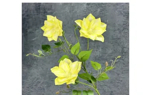 Close-up of yellow 3D printed clematis with three lifelike heads and green foliage