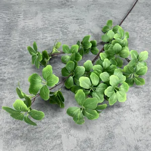 Close-up of green artificial foliage with realistic leaf veins and textured brown stems