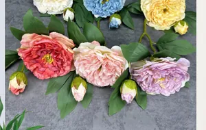 Detailed view of artificial peonies with multi-layer petals and green foliage in various colors