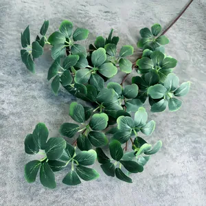 Close-up of realistic faux greenery branch showing detailed veins and green oval leaves