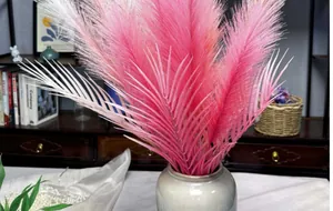 Dettaglio di canne finte rosa e bianche in un vaso di ceramica per decorazione