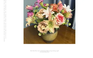 Detail of faux rose and lily bouquet in a textured brown ceramic vase for home decor