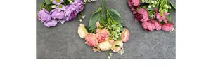 Vista dettagliata di bouquet di peonie in seta viola, champagne e rosso con foglie verdi