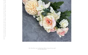 Primer plano de peonías y rosas color champán sobre un fondo de tela gris texturizada