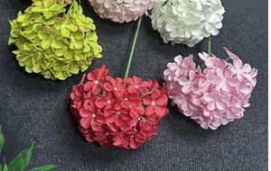 Detail van kleurrijke kunstmatige hortensia's in rood, groen en roze op donkere ondergrond