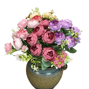 Composizione di peonie e rose artificiali in un vaso di ceramica scura decorativa