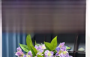 Close-up of artificial purple jasmine flowers with 3D printed texture and green leaves