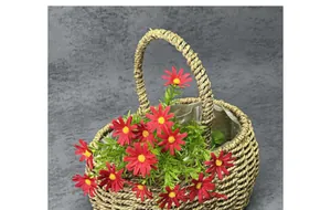 Detailed top view of red artificial daisies in a natural fiber woven basket with handle