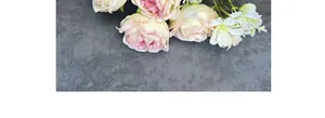 Draufsicht auf künstlichen Pfingstrosenstrauß mit rosa-weißen Blüten und grünen Blättern